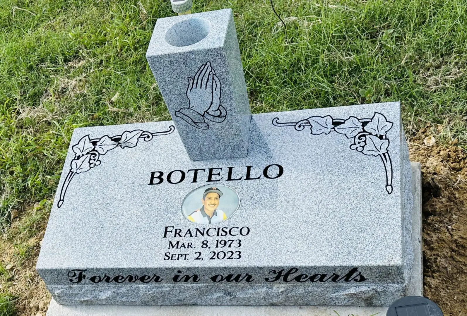 A grave stone with a picture of a man.