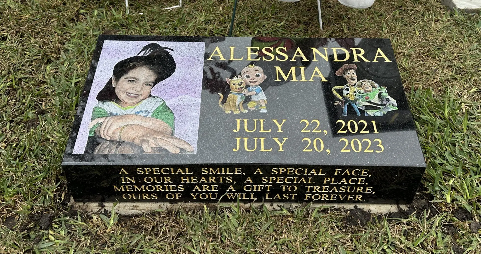 A gravestone with a picture of a girl and a dog.