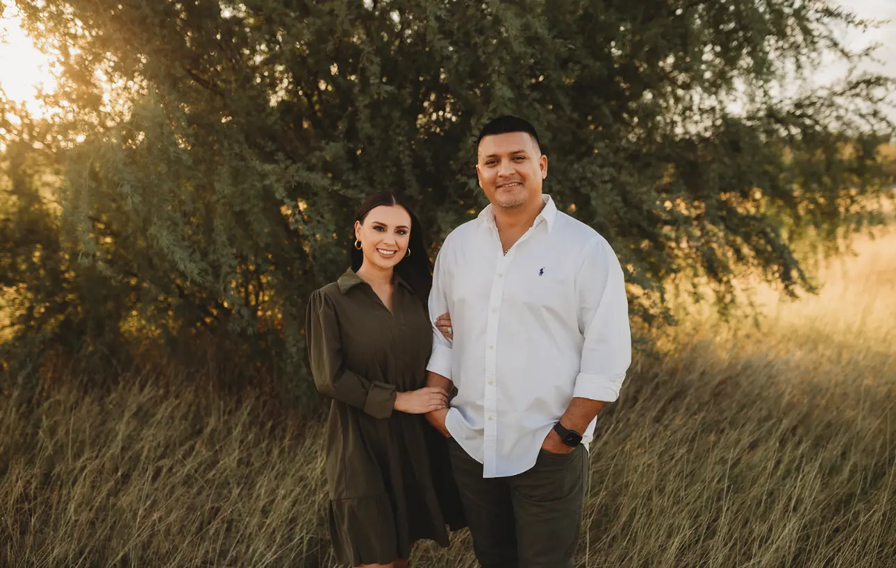 A man and woman standing in a field.