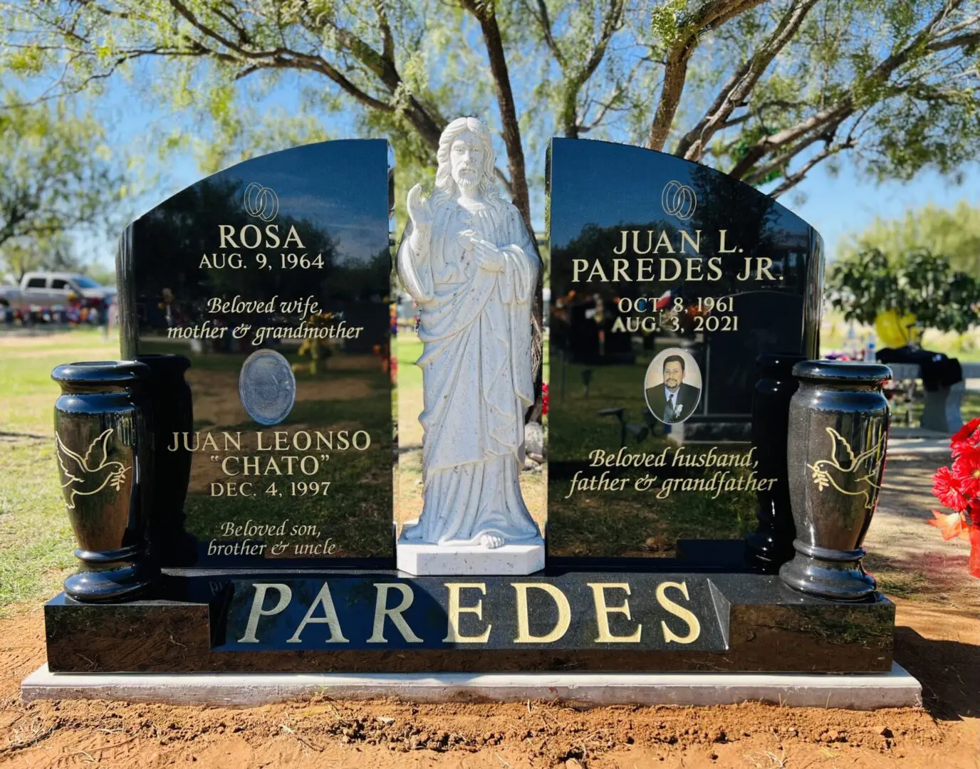 A gravestone with a statue of a woman and a statue of a man.