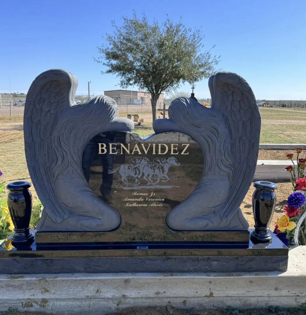 A grave stone with wings and flowers.