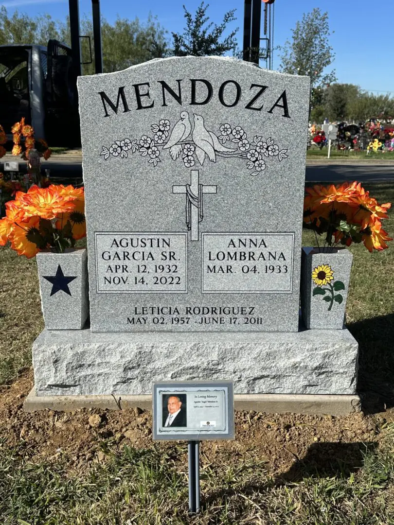 A headstone with flowers and a picture of a man.