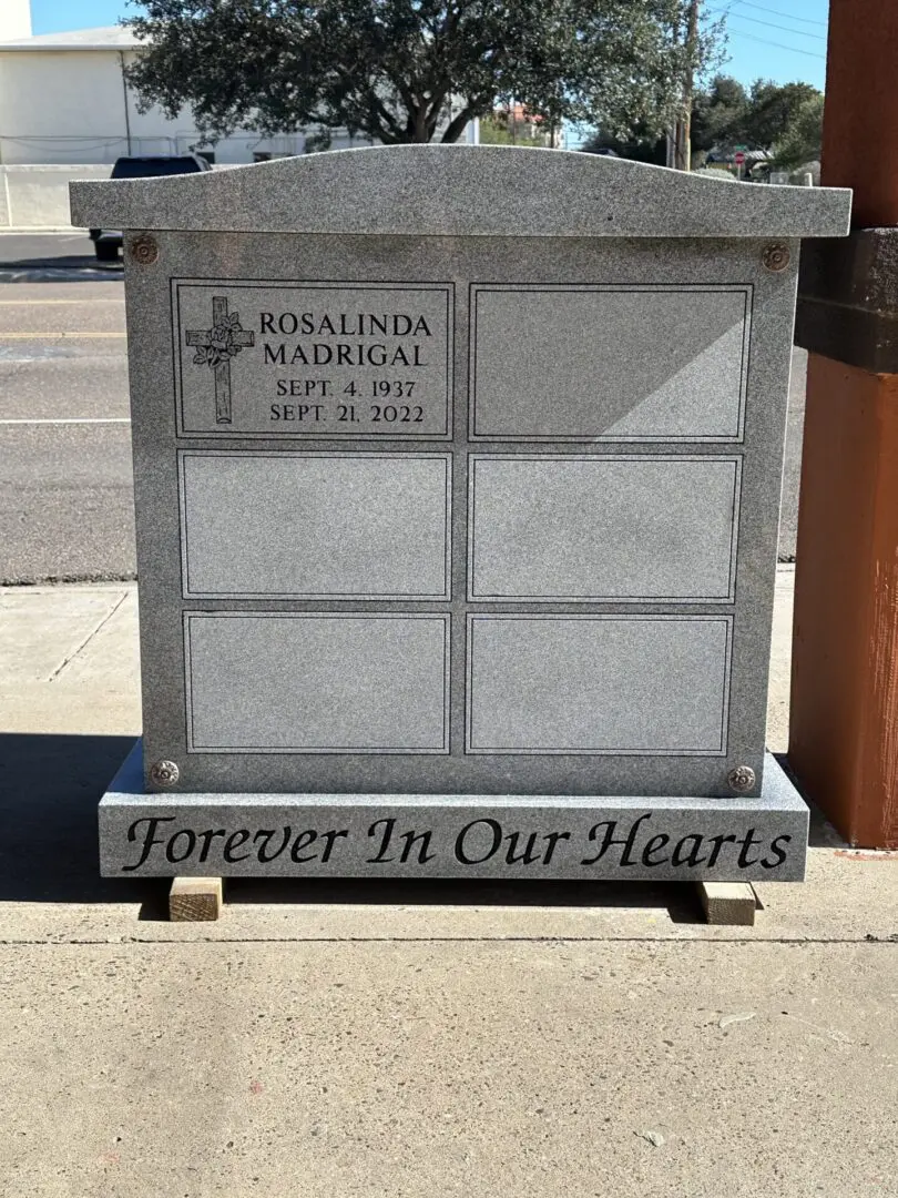 A grave stone with a cross and text.