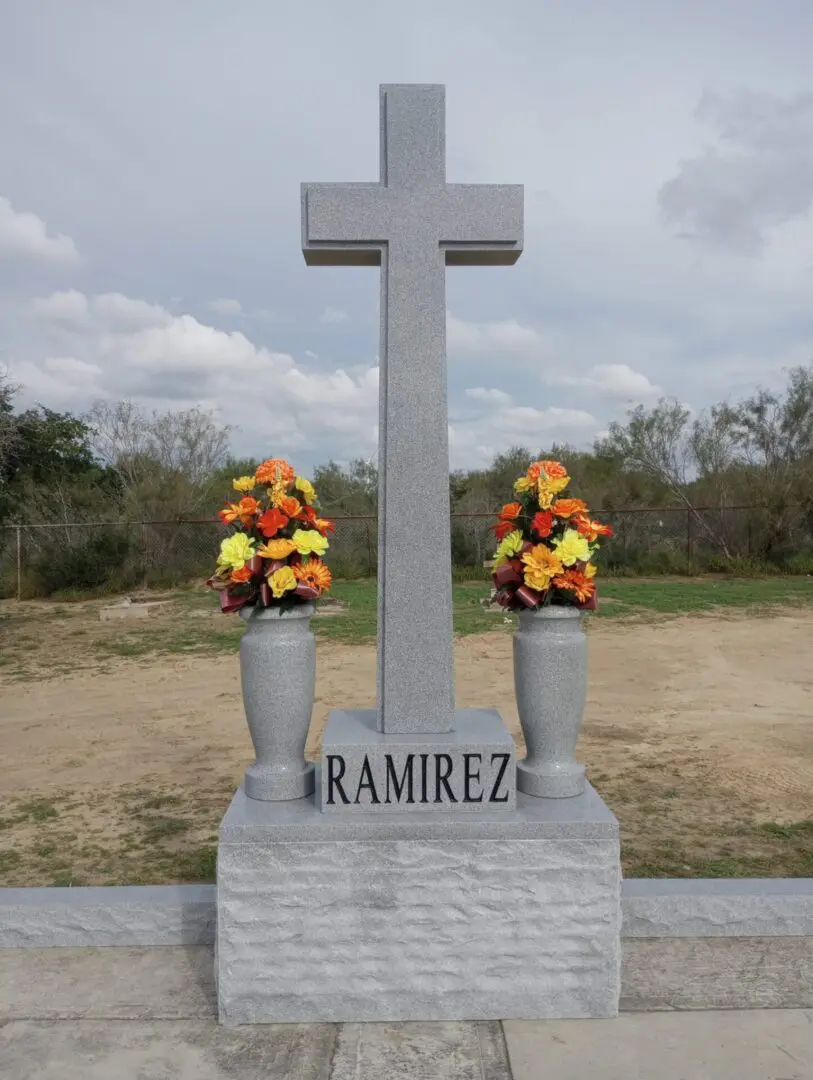 A cross with flowers in vases.